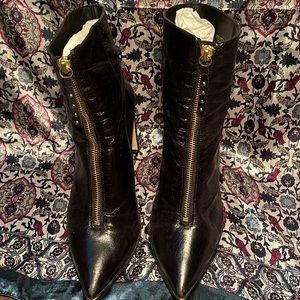 Black, flat-heeled boots with gold middle zipper and studded puller